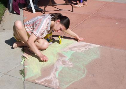Staff member Elise Olson doing chalk art at First Responders Day.