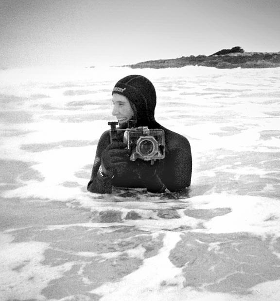 Artist Camille Lenore in the water with her camera.