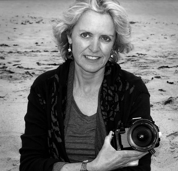 Artist Robin Robinson with her camera on a beach.