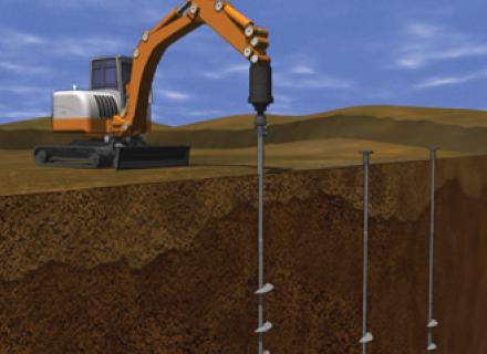 Drilling footers into soil.