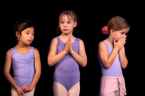 Three young female dancers prepare for dancing.