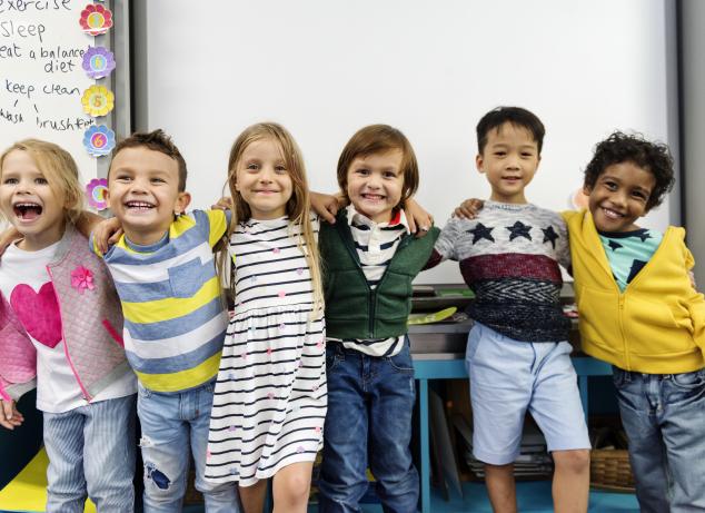 Kids in classroom posing for a picture.